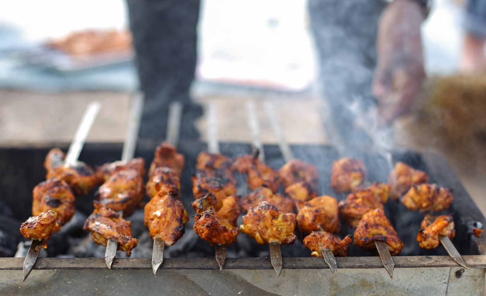 The Bright Grillzz grill master tending an open flame at an event